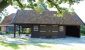 Houten kapschuur met veranda en carport.